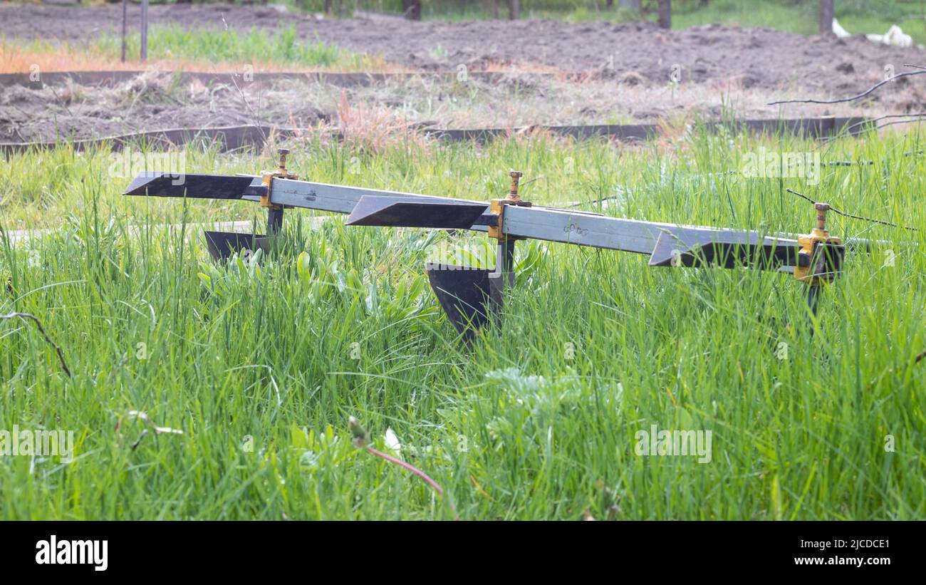 Landwirtschaftliche manuelle Metallpflug auf dem Feld. Das Land vor der Aussaat pflügen. Nahaufnahme. Inventar für das Pflügen von Kartoffeln auf dem Land. Ein Pflug ist ein Stockfoto