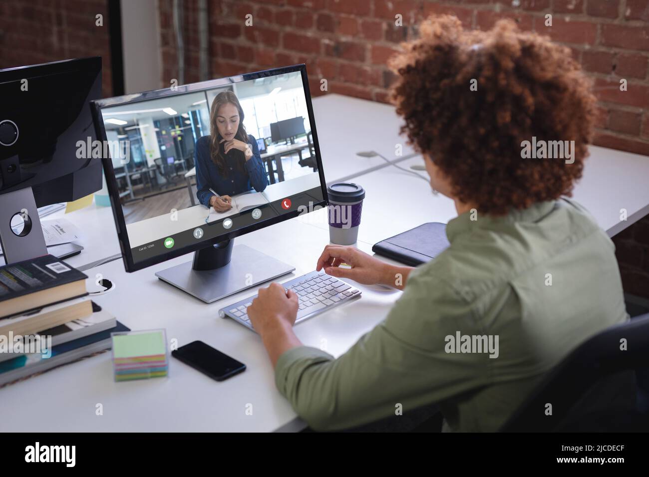 Biracial Geschäftsmann diskutiert Strategien mit weiblichen Kollegen über Desktop-pc im Büro Stockfoto