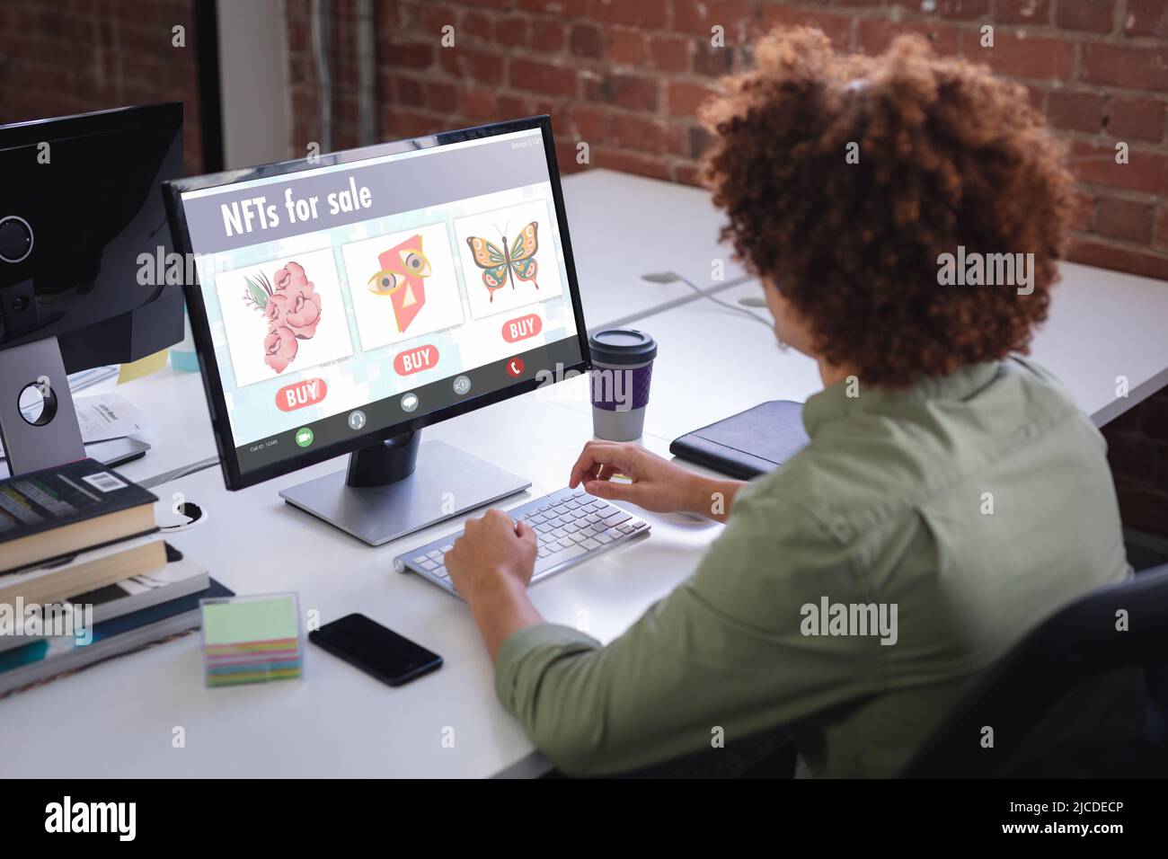 Biracial Geschäftsmann, der während der Arbeit am Desktop-pc im Büro an nfts forscht Stockfoto