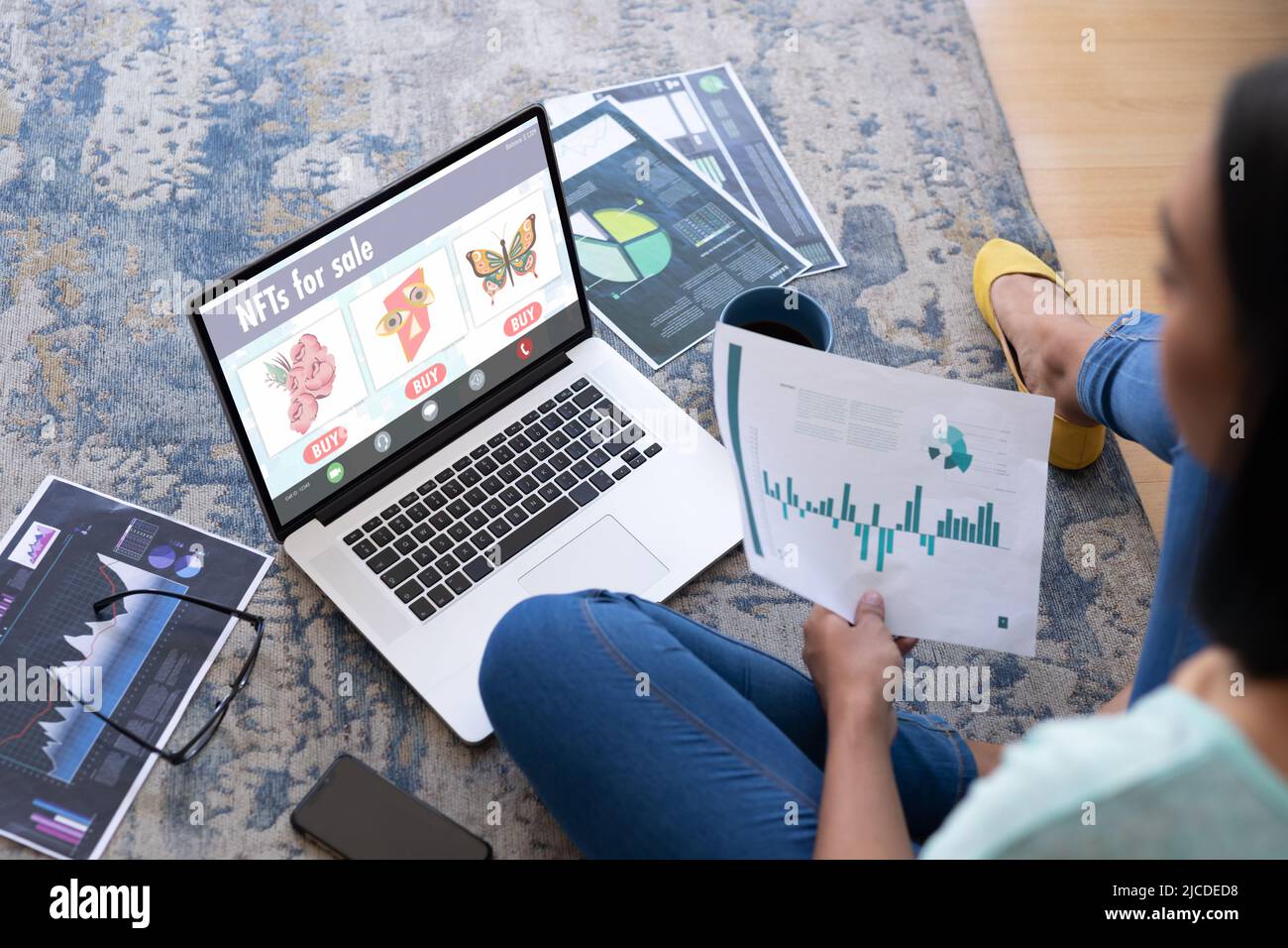 Asiatische Frau studiert Graphen, während sie zu Hause über einen Laptop über nfts recherchiert Stockfoto