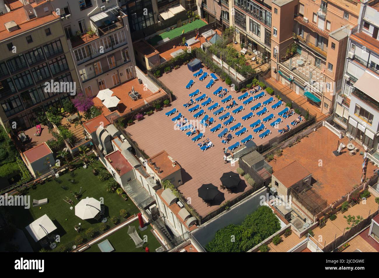 Barcelona, Spanien - 29. Mai 2022: Menschen, die sich im Urlaub sonnen, liegen auf der Terrasse eines Gebäudes auf ihren Hängematten, von oben gesehen. Stockfoto