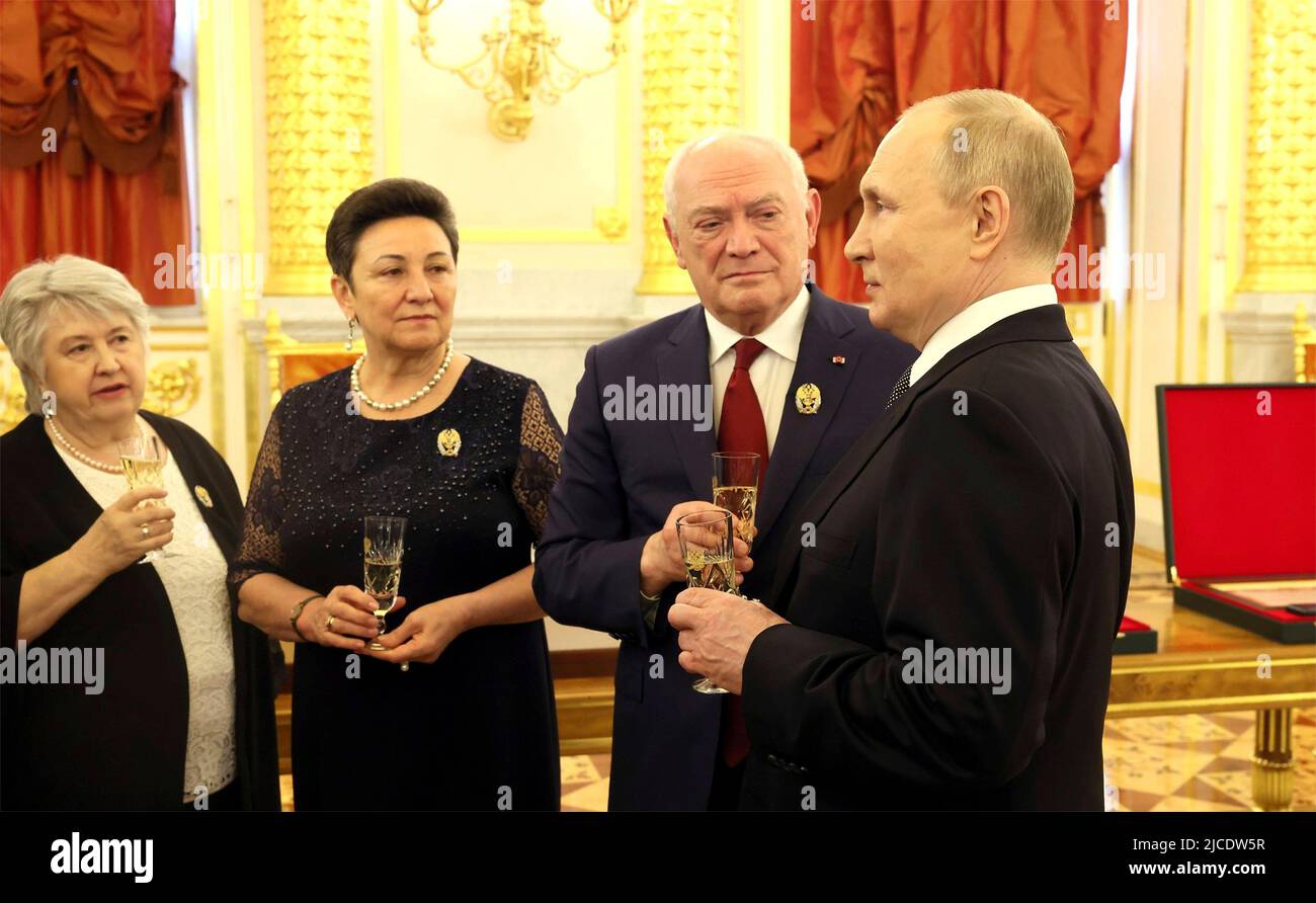 Moskau, Russland. 12.. Juni 2022. Der russische Präsident Wladimir Putin chattet mit den Empfängern staatlicher Auszeichnungen während eines Empfangs im Anschluss an die jährliche Zeremonie zur Feier des Russlandtags in der St. Georges Hall im Großen Kremlpalast am 12. Juni 2022 in Moskau, Russland. Quelle: Mikhail Metzel/Kremlin Pool/Alamy Live News Stockfoto