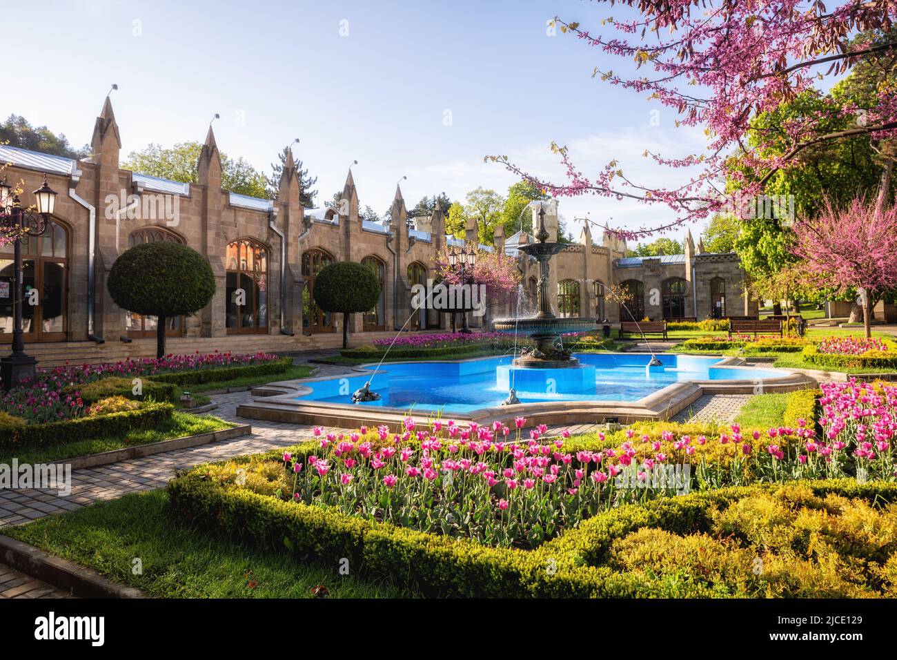 Altes Gebäude der Narzan Galerie mit Blumenbeeten und einem Brunnen, Kislowodsk, Russland Stockfoto