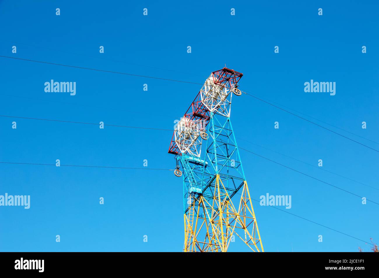 Hochspannungsleitungen auf Pylonen am blauen Himmel. Stockfoto