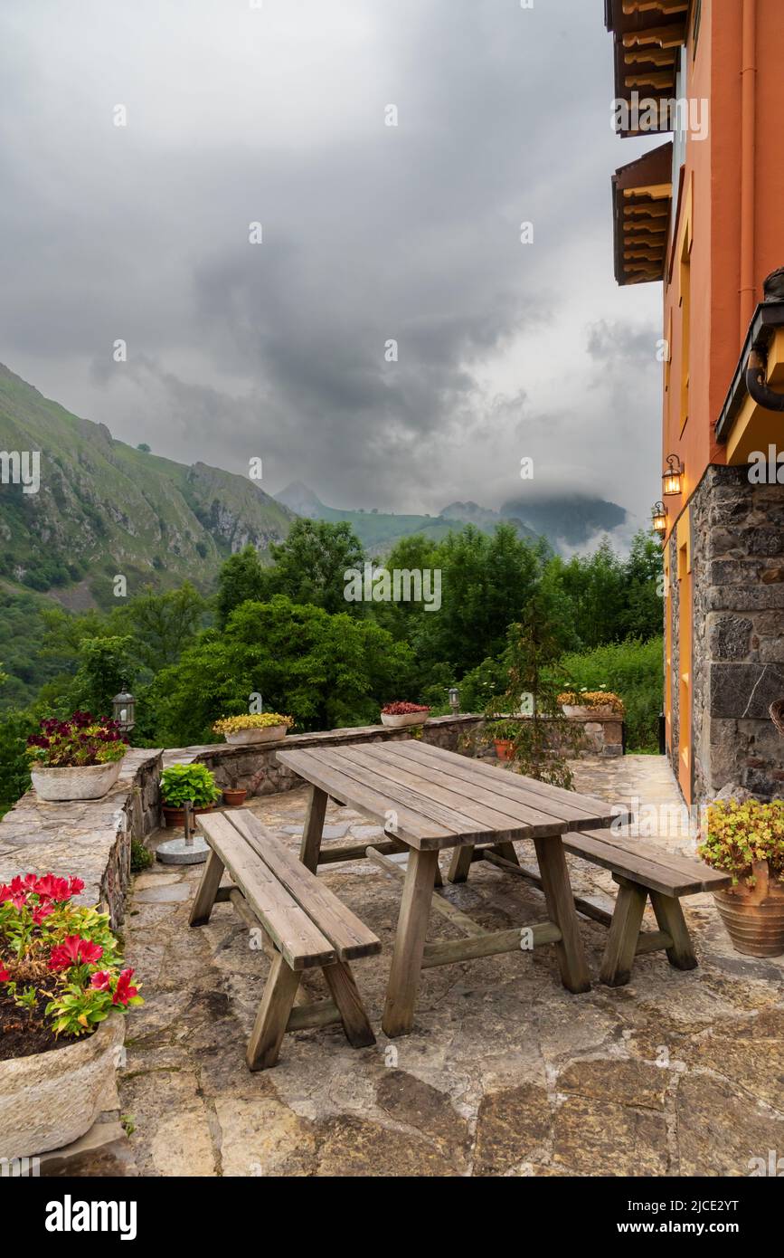 Hocker und Holztisch in einem Haus mit Blick auf die asturischen Berge. Stockfoto