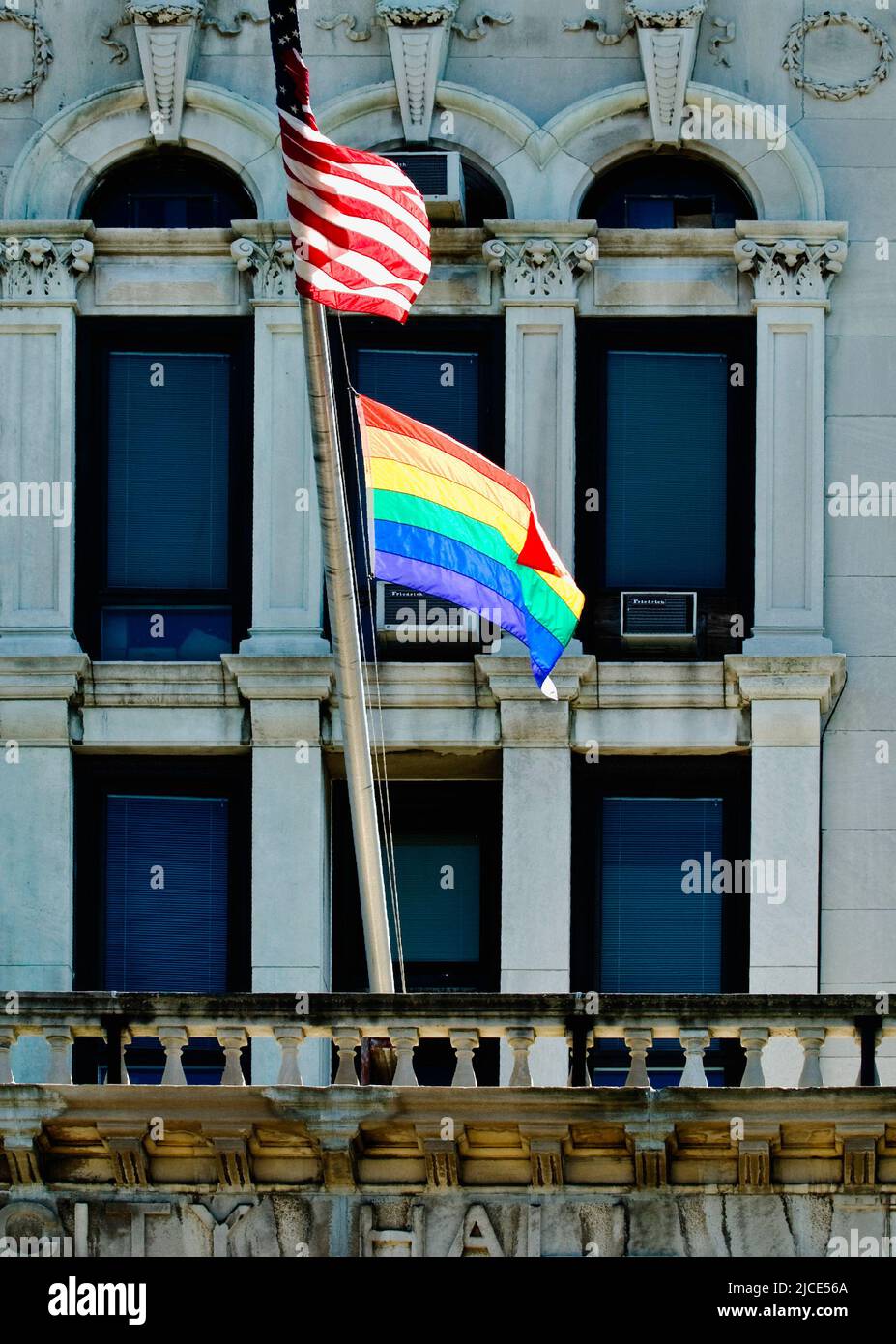 Regenbogenflagge und die amerikanische Flagge im Rathaus von Jersey für den Pride Month Stockfoto