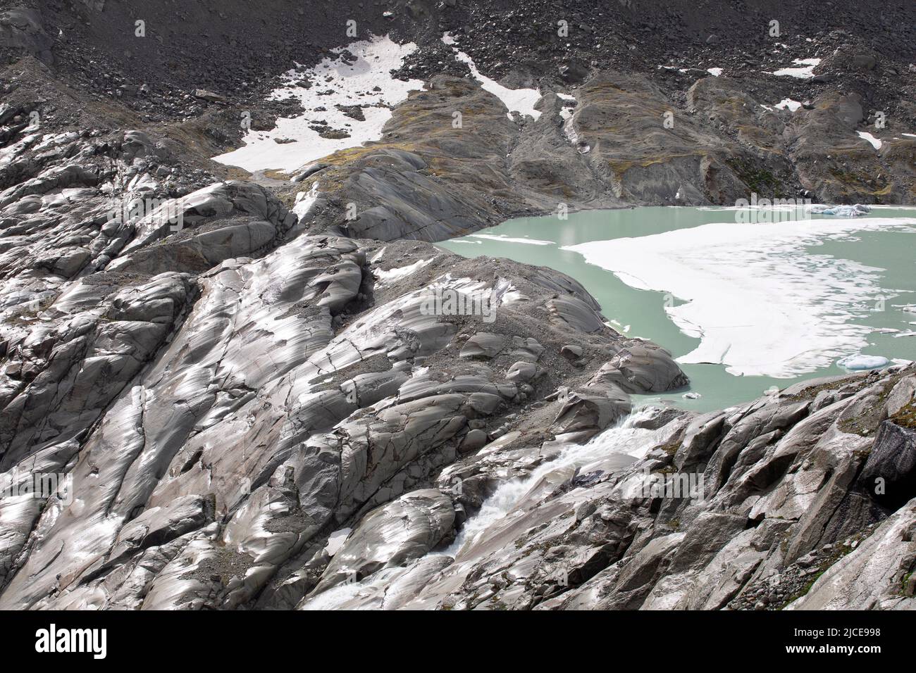 Quelle des rhone-Flusses, Gletschersee fällt als Wasserfall zwischen Bergfelsen. hochalpen Landschaft von unwegsamem Gelände. Stockfoto