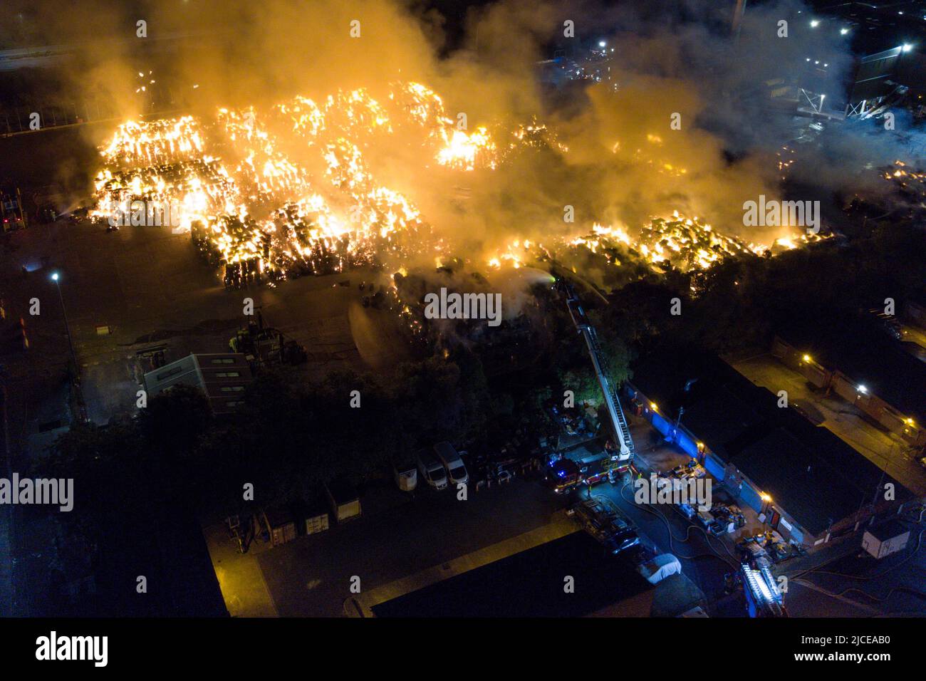 Nechells, Birmingham, England, 12. Juni 2022. Mehr als 100 Feuerwehrleute bekämpfen ein riesiges Inferno auf dem Smurfit Kappa Recycling Compound in Nechells, Birmingham. Die West Midlands Fire Service hat 20 Geräte installiert, darunter zwei hydraulische Hubarbeitsbühnen, mehrere Löschfahrzeuge und eine Hochvolt-Wasserpumpanlage. Bei dem Vorfall werden 8000 Tonnen Papier- und Pappballen in einem Lagerhaus in Brand gesetzt. Quelle: Stop Press Media/Alamy Live News Stockfoto