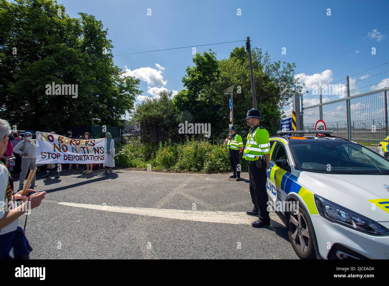 Die Polizei steht am 12. Juni 2022 in London, England, an einer Straßensperre in der Nähe des Brook House Immigration Removal Center Wache. Stockfoto