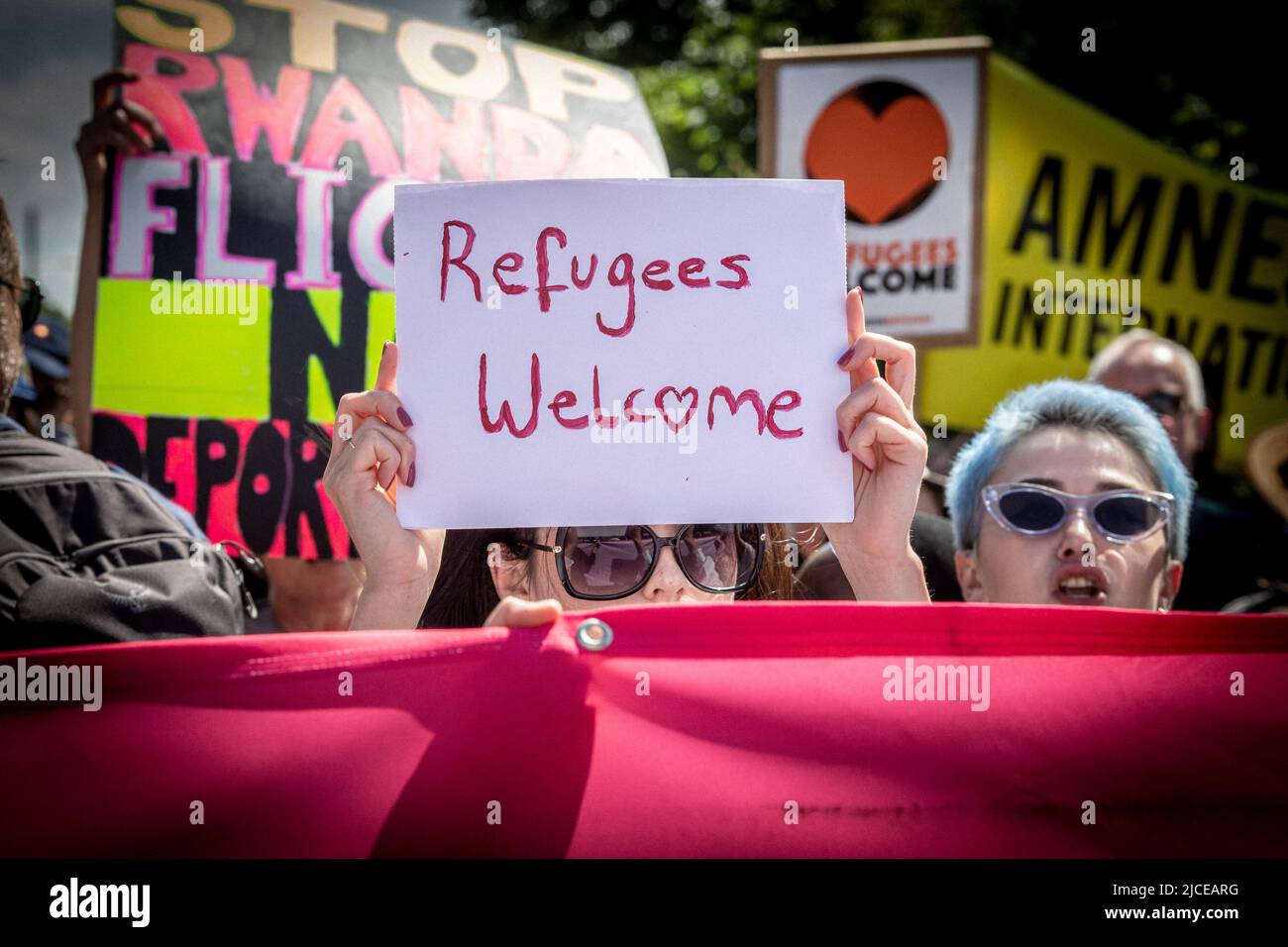 Protestler halten Plakat Flüchtlinge willkommen in London, England. Stockfoto