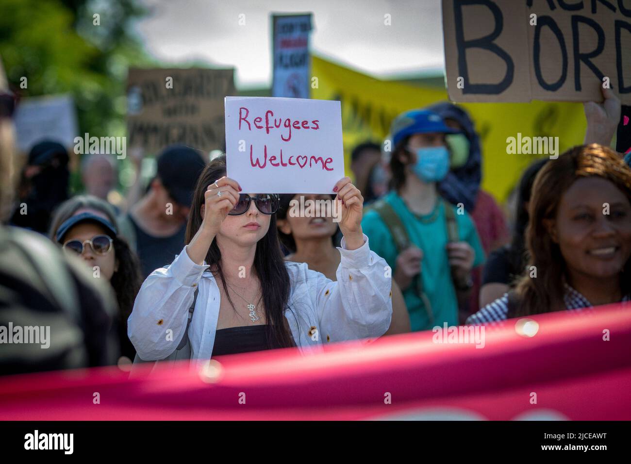 Protestler halten Schild Flüchtlinge in London, England willkommen. Stockfoto