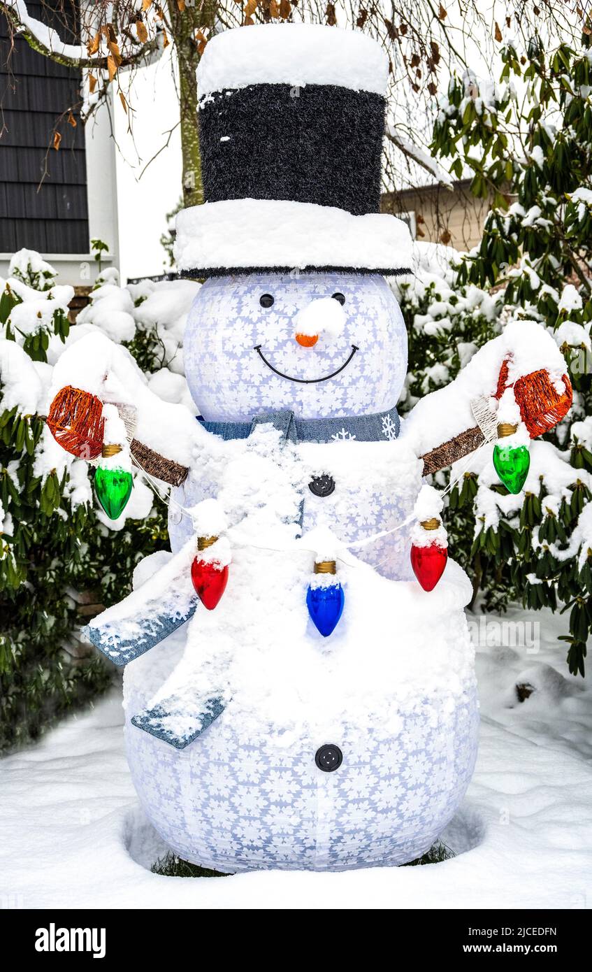 Sprengen Sie die Schneemann-Dekoration vor einem Haus zur Weihnachtszeit in die Luft Stockfoto