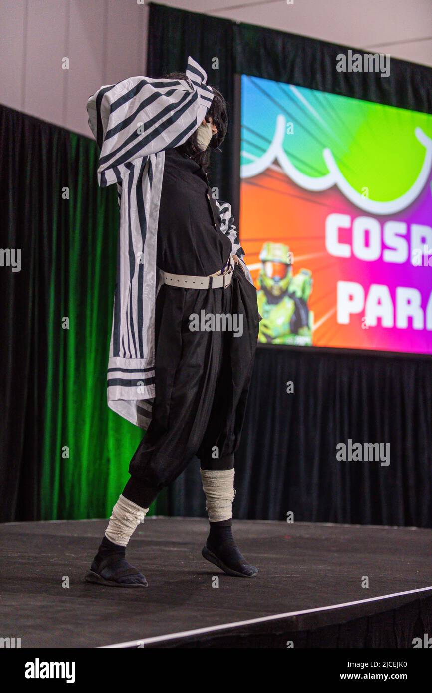 Melbourne, Australien. 12.. Juni 2022. Ein Cosplayer in einem Dämon Slayer Kostüm nimmt an einer Cosplay Parade Teil, um ihre Schöpfung auf der OzComicCon 2022 zu zeigen. Auf der OzComicCon kamen Tausende von Fans der Popkultur für das Wochenende ins Melbourne Exhibition Center, um sich an Foren, Cosplay-Wettbewerben und Promi-Ratespielen zu erfreuen. Der erste Tag der Veranstaltung war ein Ausverkauf mit Menschen, die nach verschobenen und abgesagten Veranstaltungen unter COVID-Sperre in Massen zur Convention zurückkehrten. Kredit: SOPA Images Limited/Alamy Live Nachrichten Stockfoto