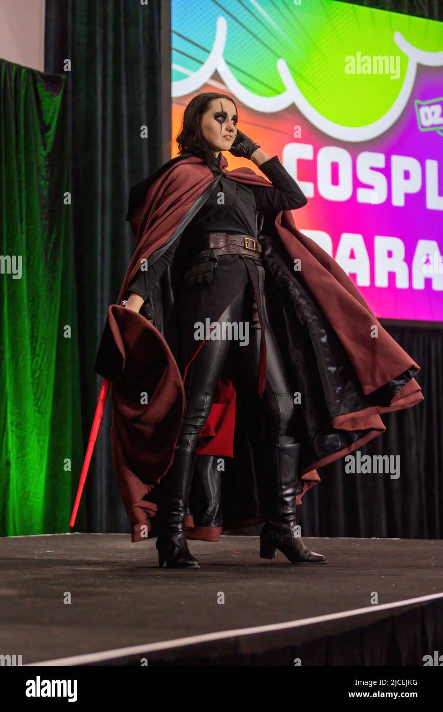 Melbourne, Australien. 12.. Juni 2022. Ein Cosplayer in einem Star Wars Sith Kostüm nimmt an einer Cosplay Parade Teil, um ihre Kreationen auf der OzComicCon 2022 zu zeigen. Auf der OzComicCon kamen Tausende von Fans der Popkultur für das Wochenende ins Melbourne Exhibition Center, um sich an Foren, Cosplay-Wettbewerben und Promi-Ratespielen zu erfreuen. Der erste Tag der Veranstaltung war ein Ausverkauf mit Menschen, die nach verschobenen und abgesagten Veranstaltungen unter COVID-Sperre in Massen zur Convention zurückkehrten. Kredit: SOPA Images Limited/Alamy Live Nachrichten Stockfoto