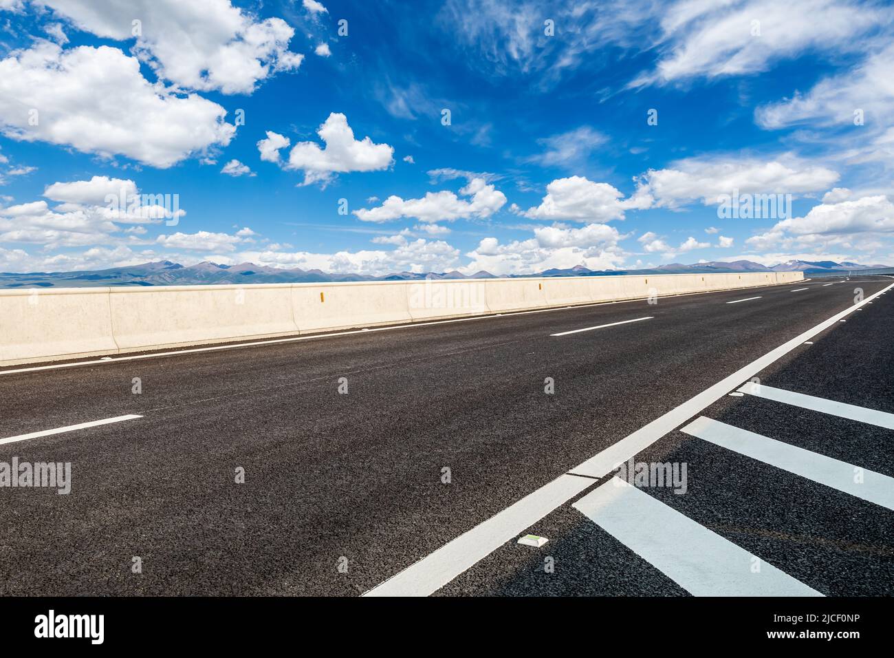 Leere Asphaltstraße und Berglandschaft unter blauem Himmel Stockfoto