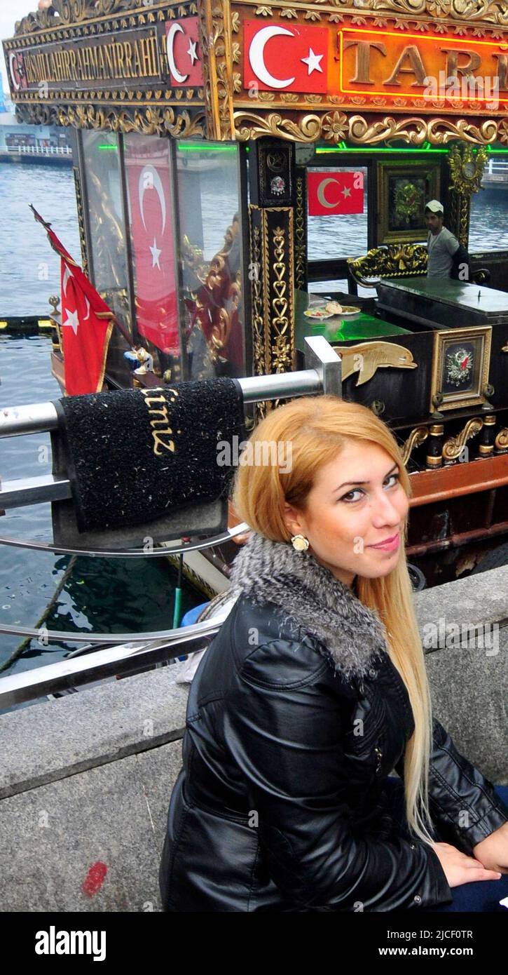 Eine wunderschöne türkische Frau sitzt neben einem Sandwich-Boot mit Makrelen in Istanbul, Türkei. Stockfoto