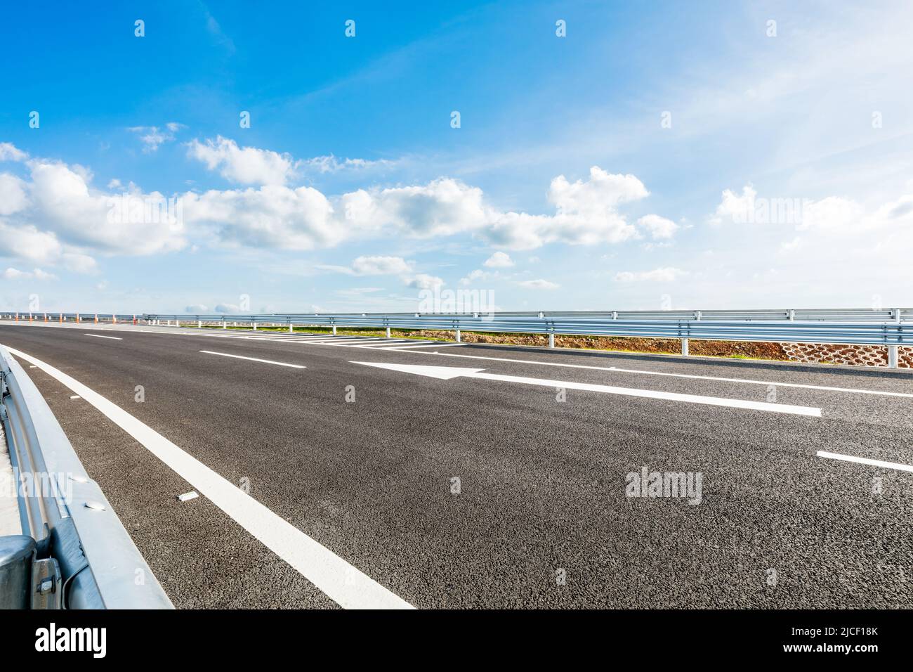 Asphaltstraße und Himmelswolkenlandschaft unter blauem Himmel Stockfoto