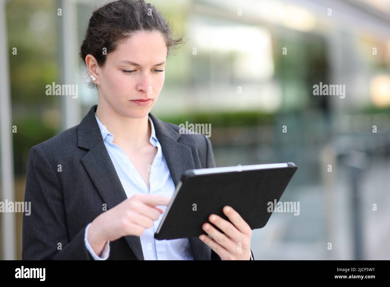 Seriöse Führungskräfte arbeiten mit einem Tablet, das auf der Straße läuft Stockfoto