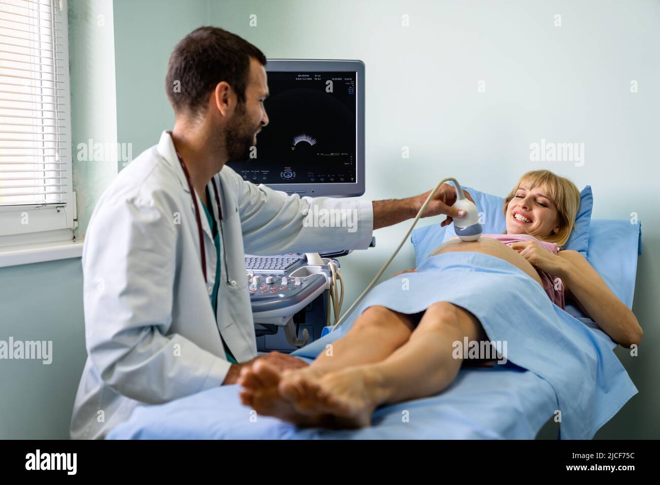 Eine Schwangerin beim Gynäkologen, die ihr Baby mit einem Ultraschallgerät untersuchen ließ. Stockfoto