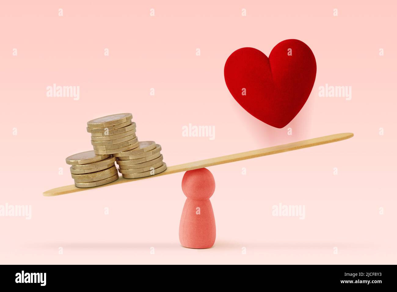 Geld und Herz auf einem rosa Hintergrund – das Konzept von Frau und Geld hat Vorrang vor der Liebe im Leben Stockfoto