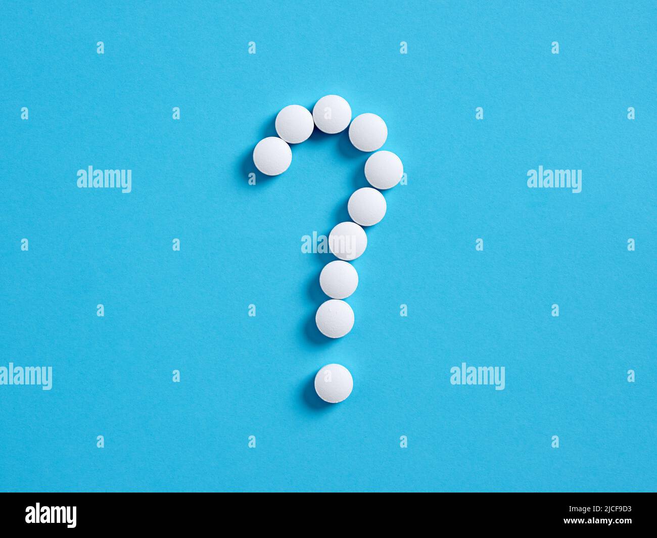 Fragezeichen-Symbol aus medizinischen Pillen auf blauem Hintergrund. Medizinische Nebenwirkung von Medikamenten Konzept. Stockfoto