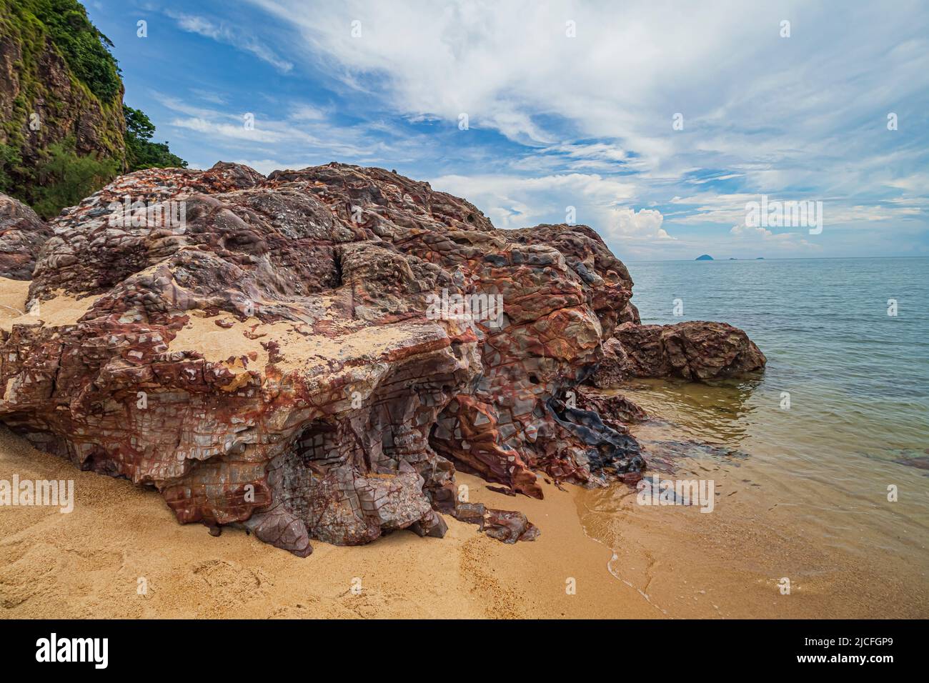 Am Strand von Pantai Dendong im Besut District von Terengganu, Malaysia, gelegene Landschaft am Meer mit Felsformationen und mit Vegetation bewachsenen Felsklippen. Stockfoto
