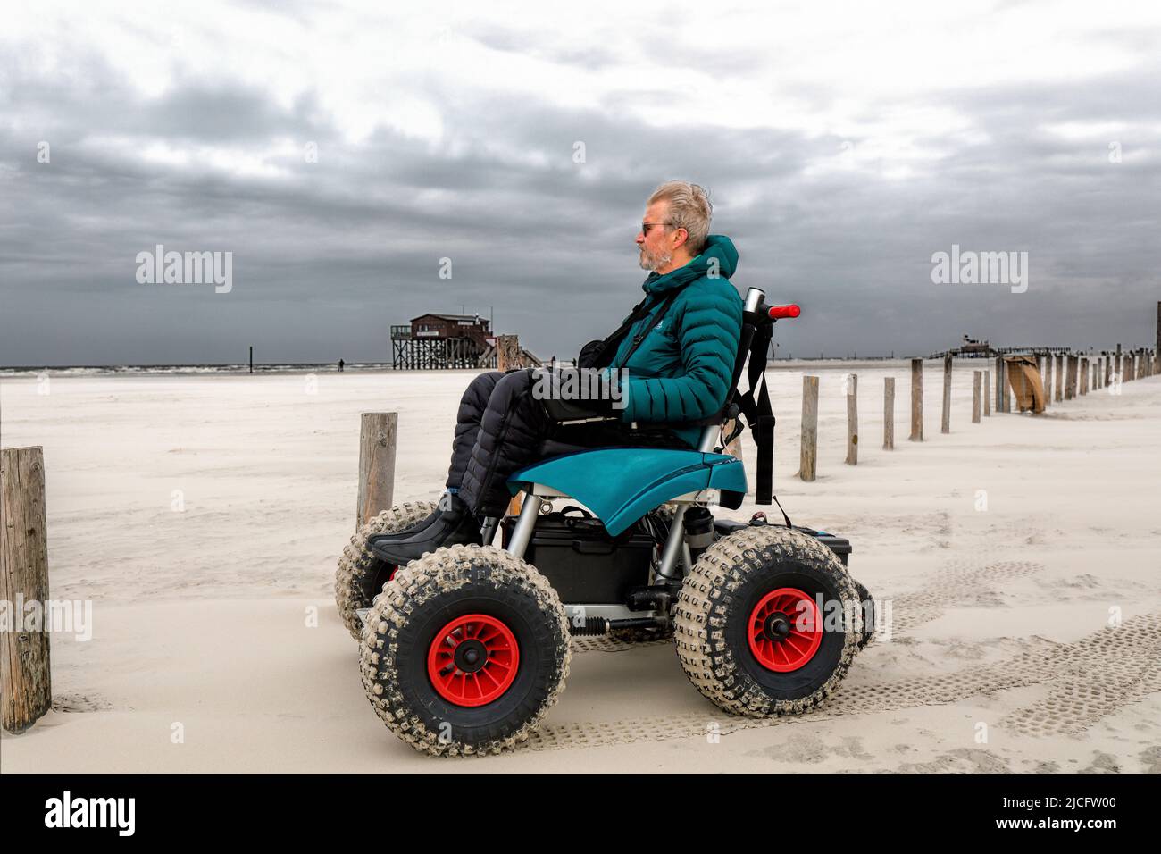 Mann im Strandrollstuhl, Strandurlaub genießen, Sankt-Peter-Ording, Schleswig-Holstein, Deutschland Stockfoto