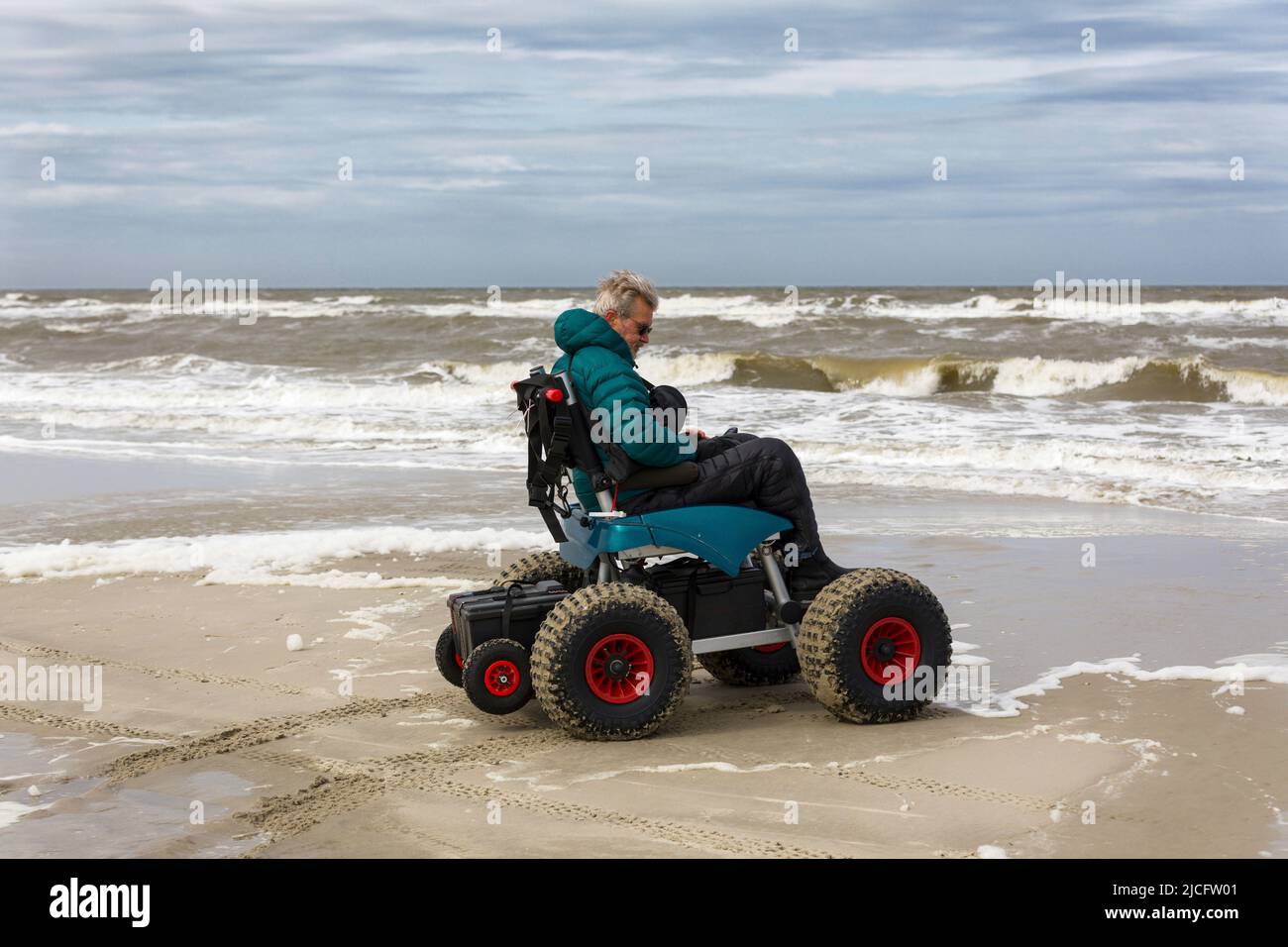 Mann mit Handicap und Strandrollstuhl Stockfoto
