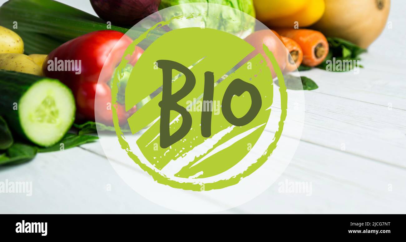 Bild von Bio-Text in grün, auf grünem Kreis, über frischem Gemüse auf weißen Brettern Stockfoto
