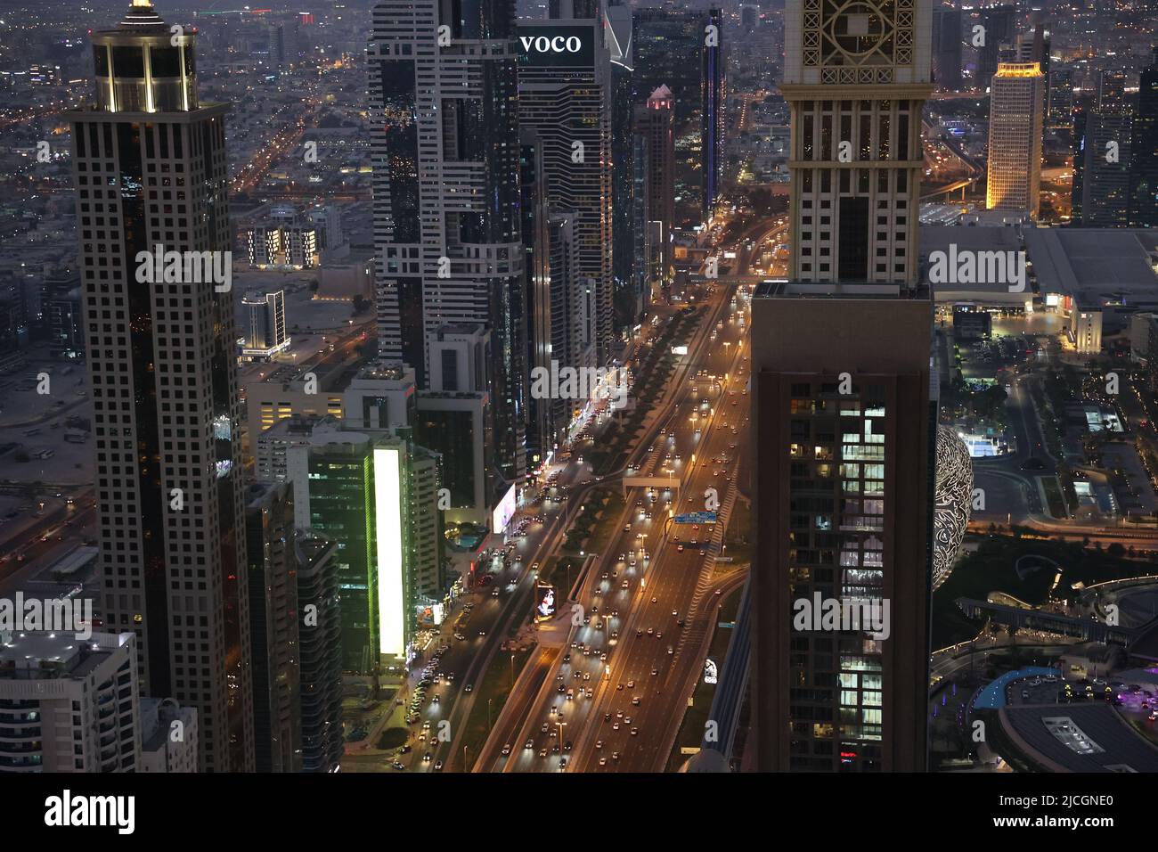 Nachtansicht auf Wolkenkratzer auf der Sheikh Zayed Road, gelbe Straßenlaternen, Dubai, VAE, Drohnenbild Stockfoto