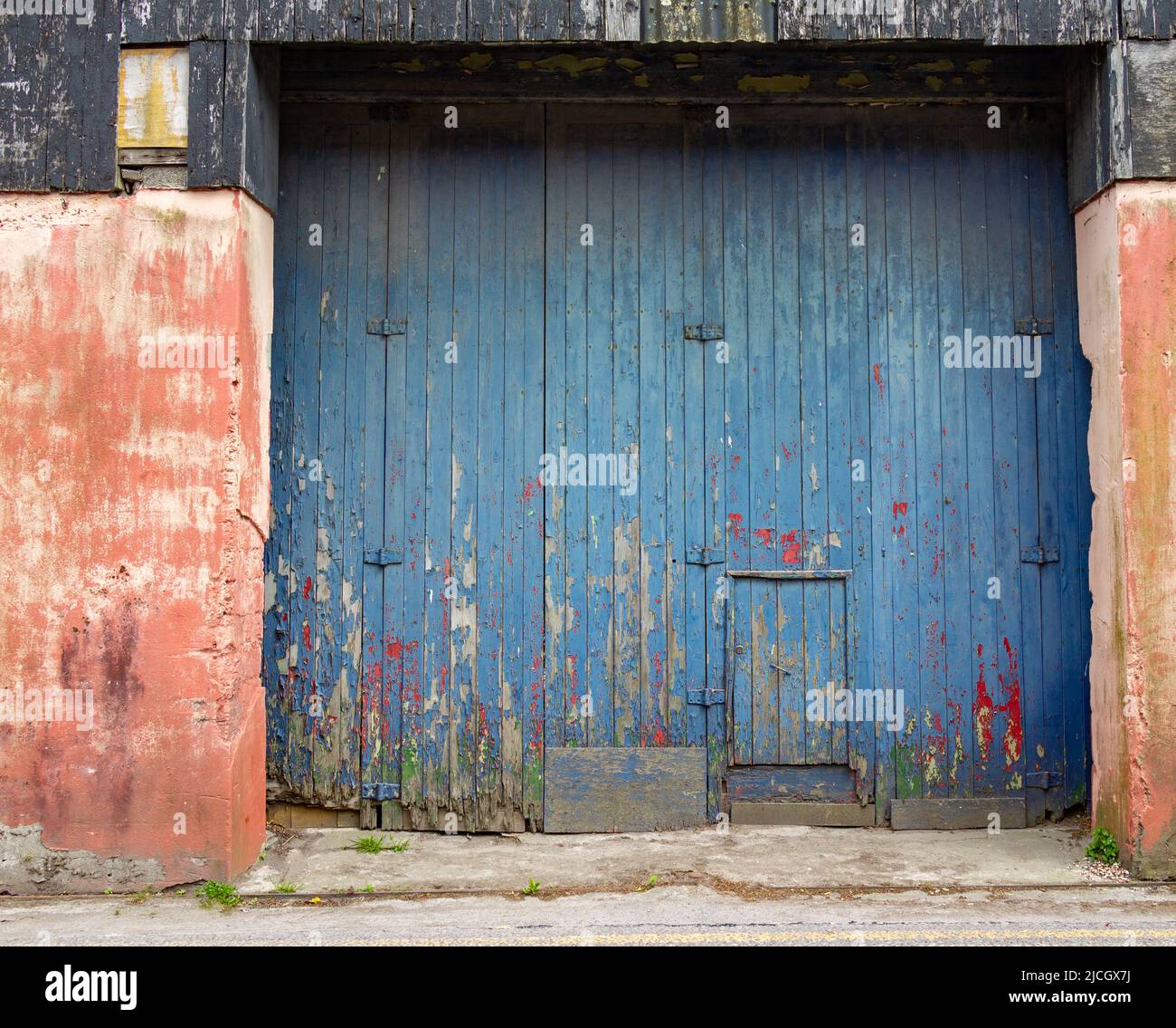 Große hölzerne Scheunentüren mit abblätternder blauer Farbe Stockfoto