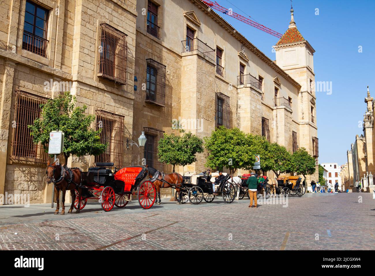 Cordoba, Spanien - Februar 11,2022: Rote Pferdekutsche neben der Moschee von Cordoba, Andalusien, Spanien. Pferdeschlittenfahrt auf der Cordoba Straße. Stockfoto