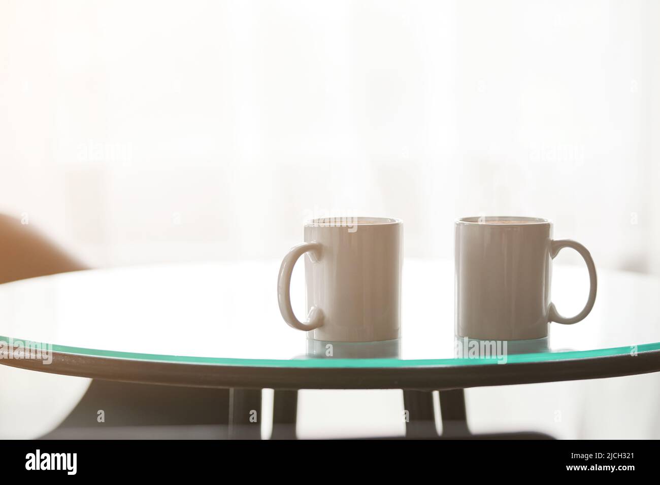 Zwei Tassen Kaffee auf einem Glastisch. Stockfoto