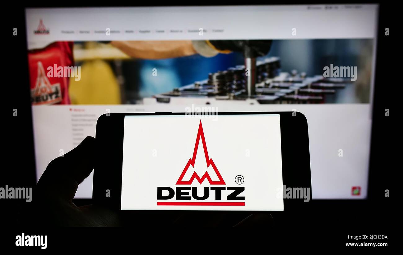 Person, die Smartphone mit Logo des deutschen Motorenunternehmens Deutz AG auf dem Bildschirm vor der Website hält. Konzentrieren Sie sich auf die Telefonanzeige. Stockfoto