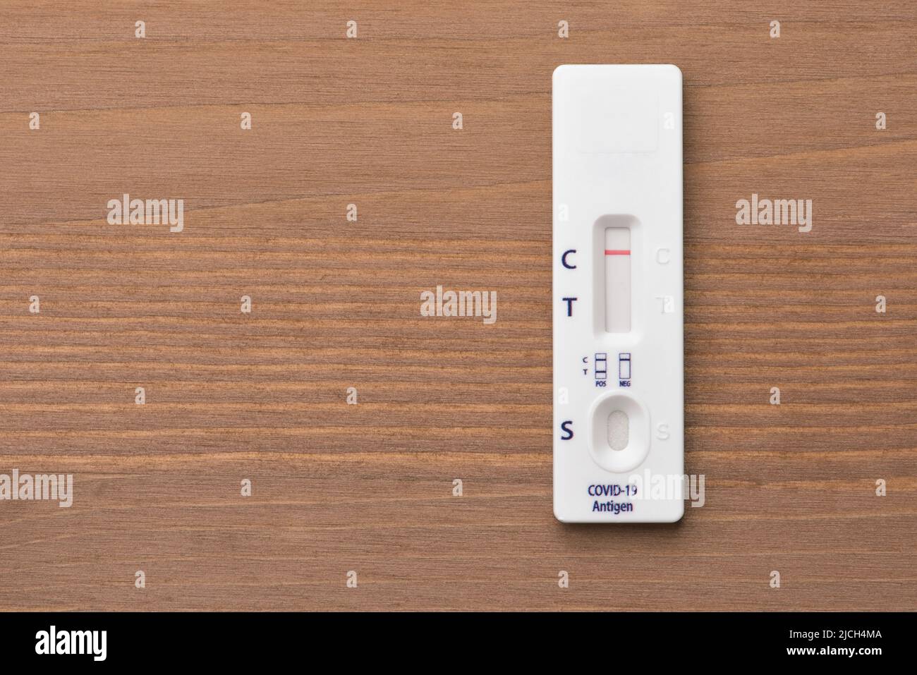 Draufsicht des schnellen COVID-19-Antigen-Selbsttests mit negativem Ergebnis auf Holzhintergrund Stockfoto