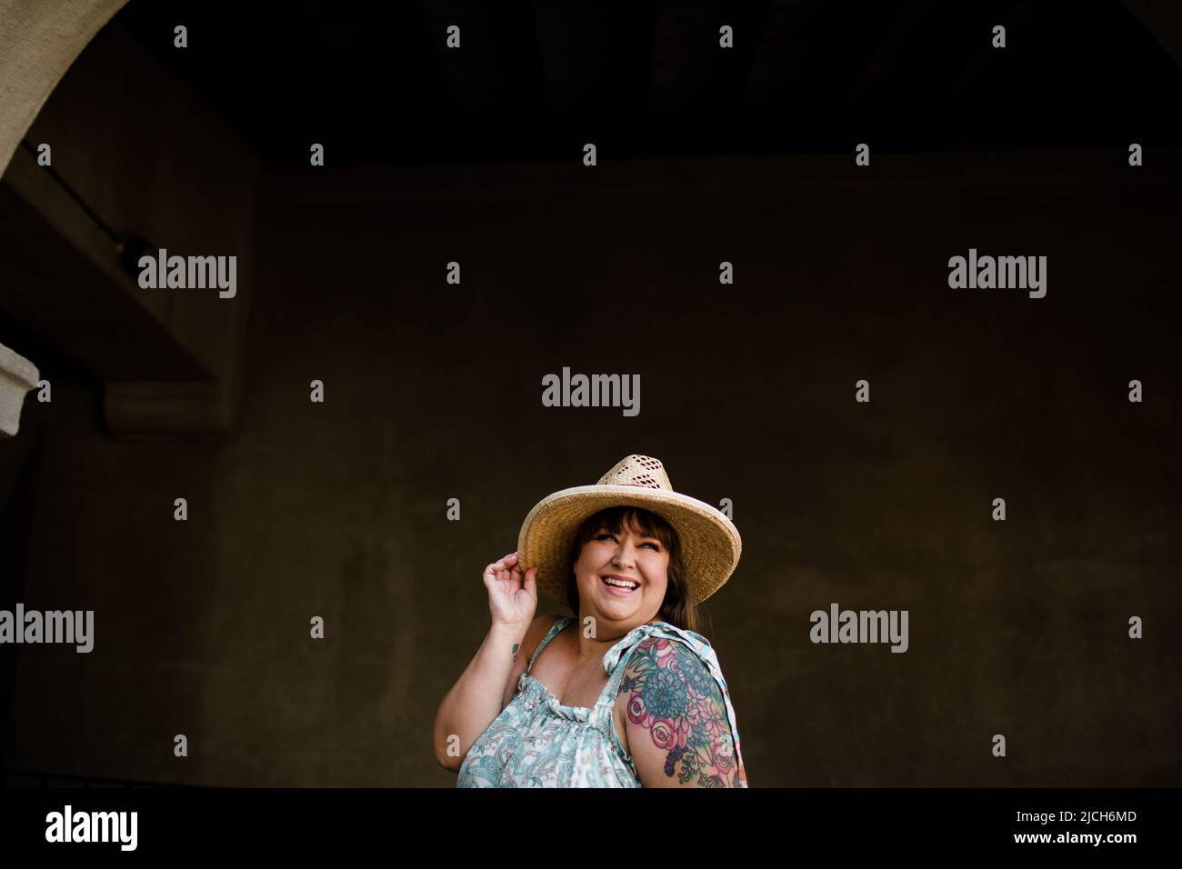 Plus Size-Modell trägt Hut und ärmelloses Kleid in San Diego Stockfoto