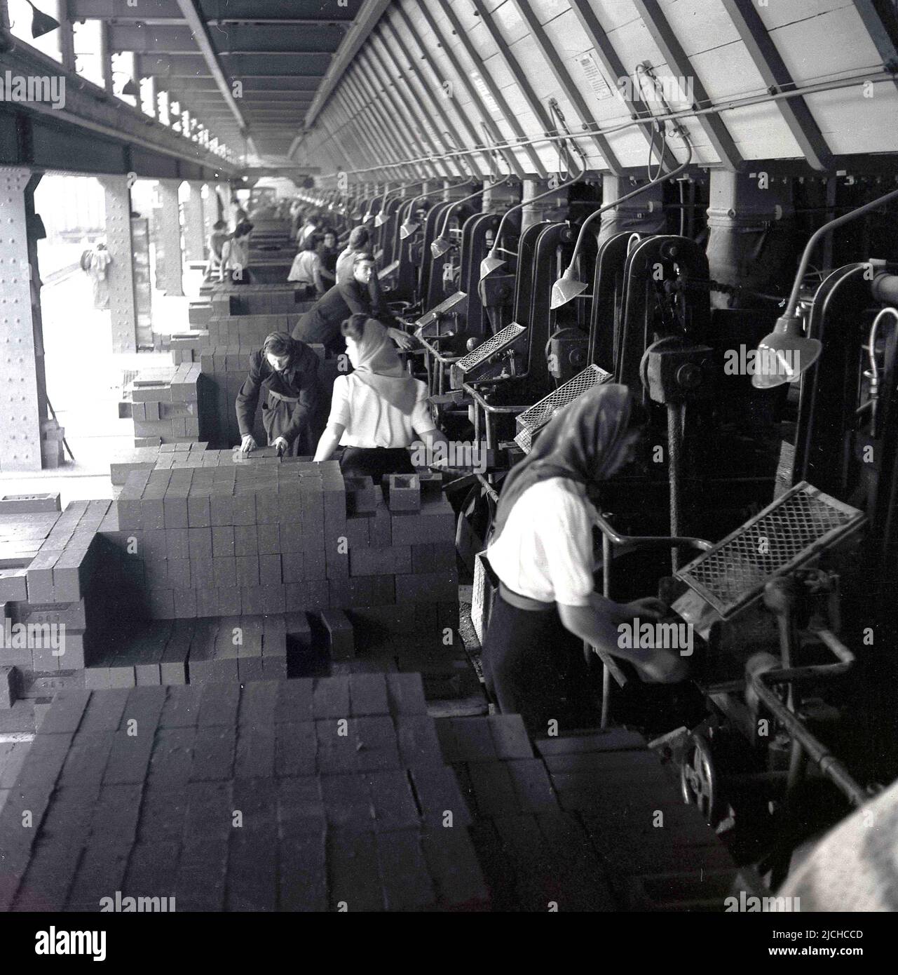 1950s, historisch, eine lange Reihe von Frauen, die bei der London Brick Company, Bedford, England, Großbritannien, arbeiten und Steine fertigstellen. Stockfoto