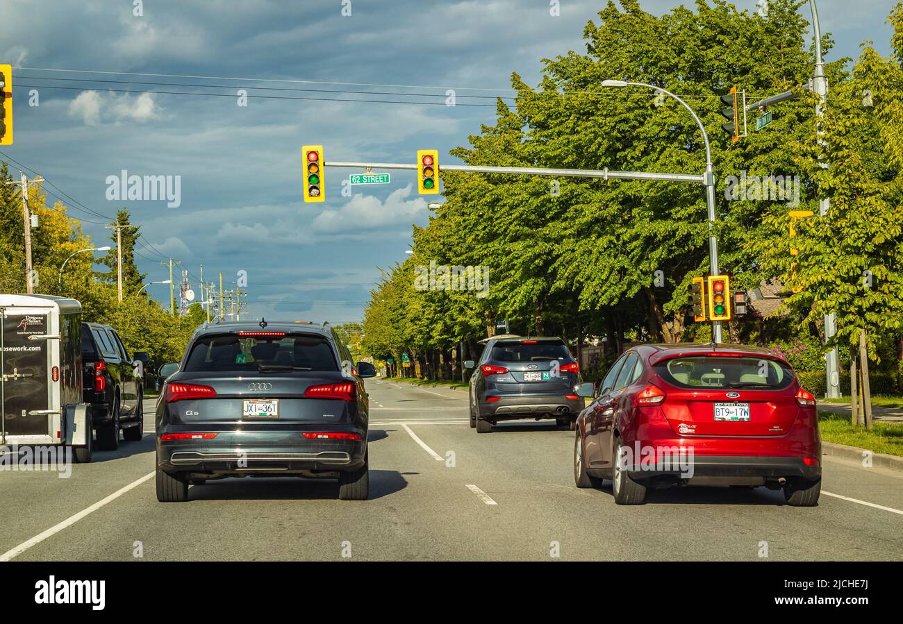 An einem bewölkten Sommertag fahren Autos auf einer Stadtstraße. Ampel auf einem Highway in British Columbia, Kanada. Reisefoto, selektiver Fokus, Straßenansicht-Ma Stockfoto