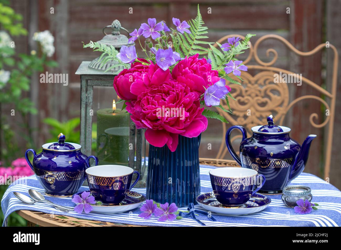 Tischdekoration mit Porzellan und Bouquet von rosa Pfingstrosen-Blüten Stockfoto