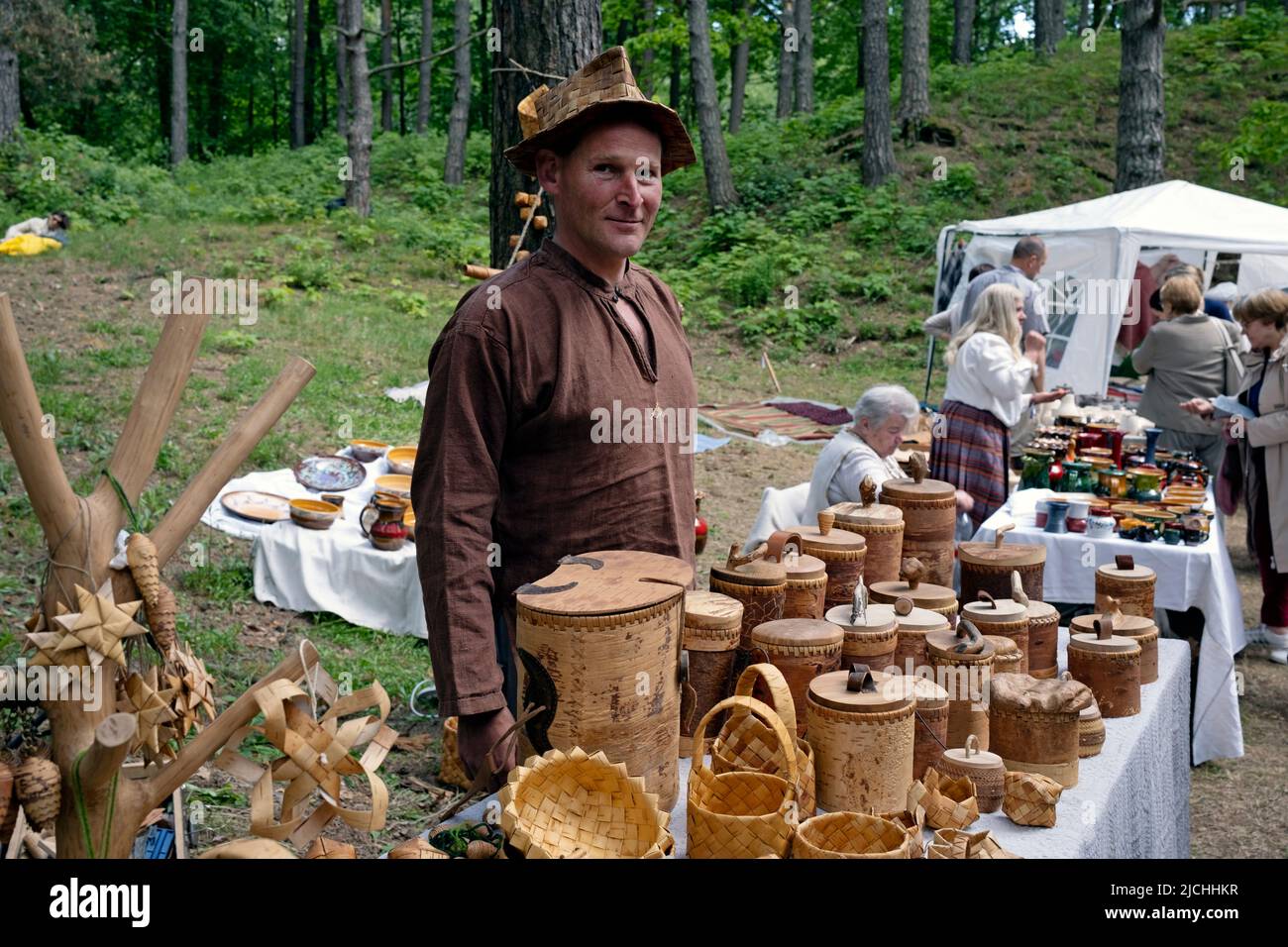 Mann, der Produkte aus Birkenrinde verkauft, im Ethnographischen Freilichtmuseum von Lettland, Riga, Lettland Stockfoto