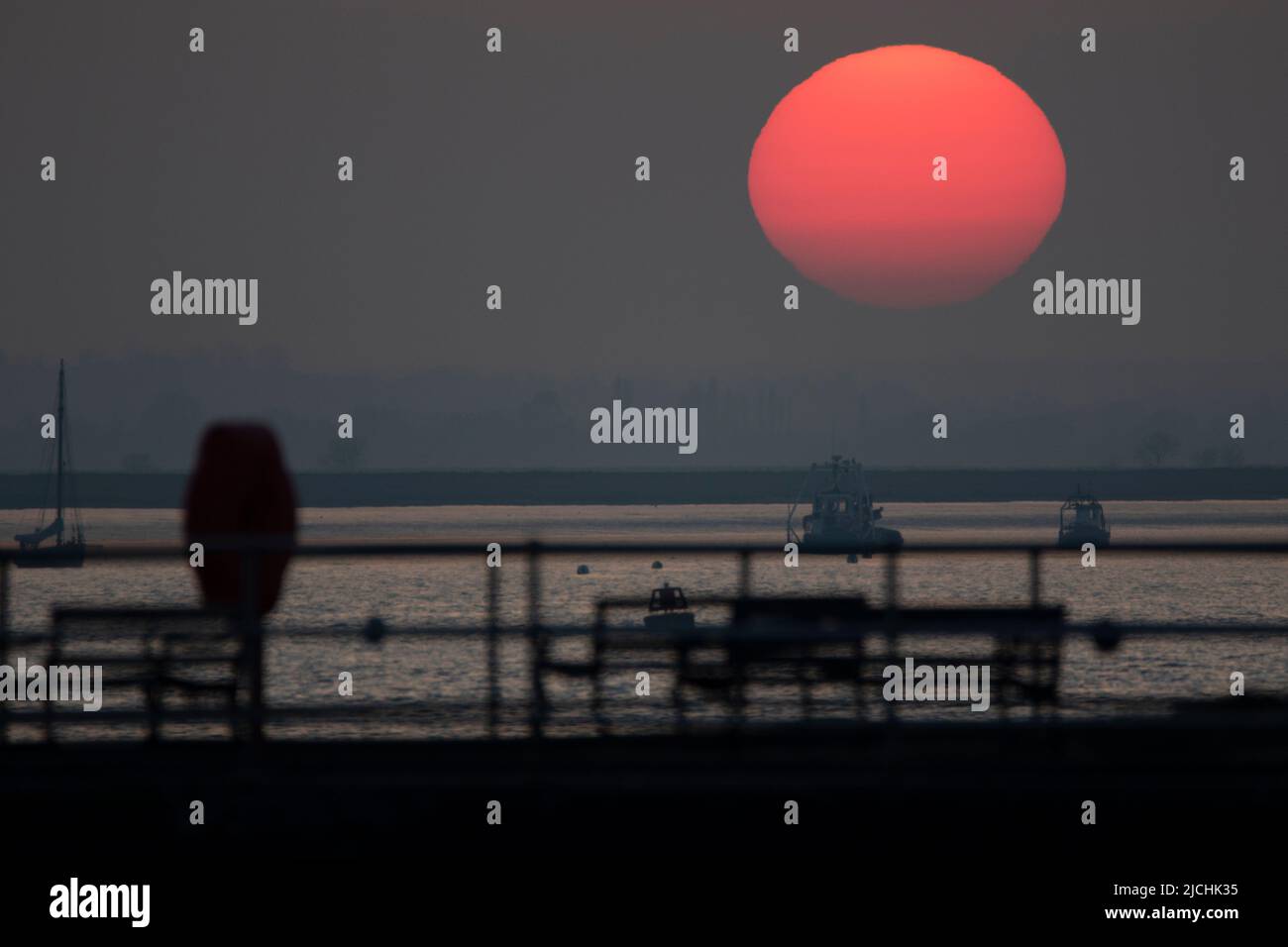 Die untergehende Sonne bei Brightlingsea in Essex UK Stockfoto