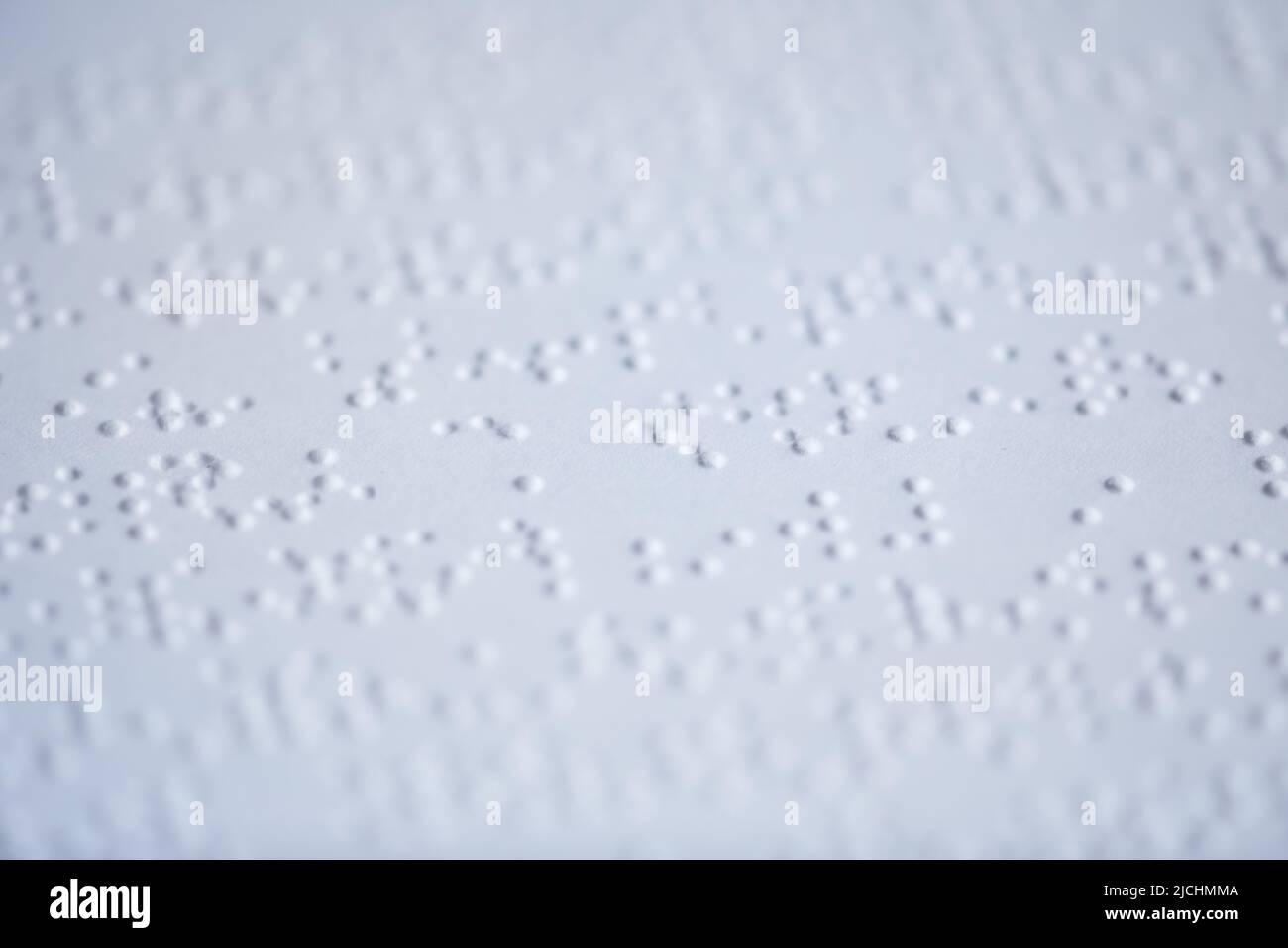 Makroaufnahme von taktiler Braille-Schrift auf weißer Buchseite, barrierefreies Informationskonzept, Kopierraum Stockfoto