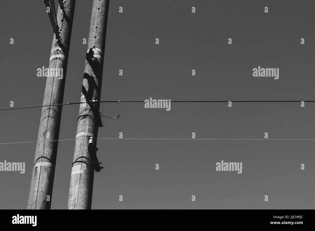 Alte hölzerne Strommasten mit Metalldrähten gegen den Himmel. Ansicht von oben. Stockfoto