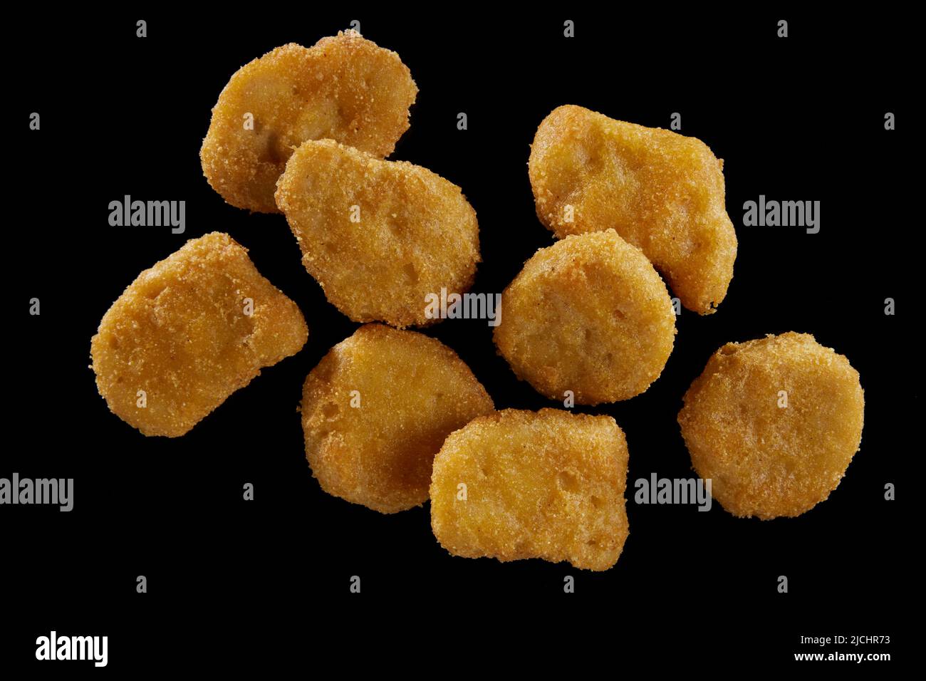 Draufsicht auf appetitliche Chicken Nuggets mit knuspriger Kruste auf schwarzem Hintergrund Stockfoto