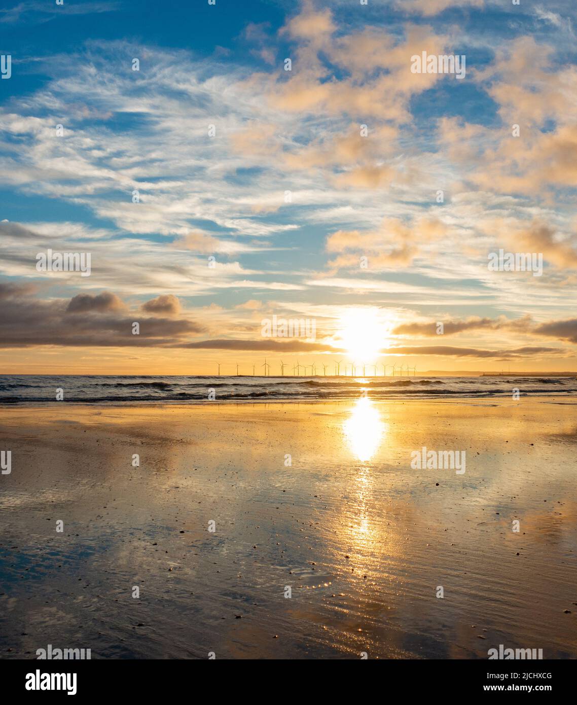 Atemberaubender Sonnenaufgang mit Spiegelungen auf dem Küstenpfad von England am Strand von Seaton Carew, Nordostengland, Großbritannien. Stockfoto