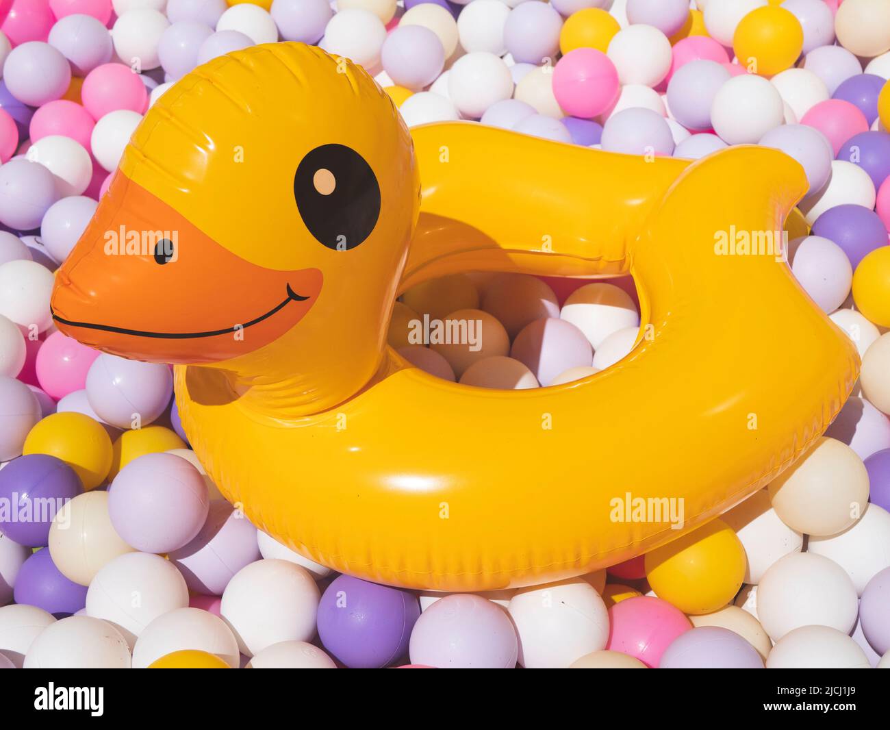 Schwimmring in Form einer gelb lächelnden Ente. Konzept der Entspannung, Freizeit und Erholung im Sommer. Strandzubehör oder -Ausrüstung Stockfoto