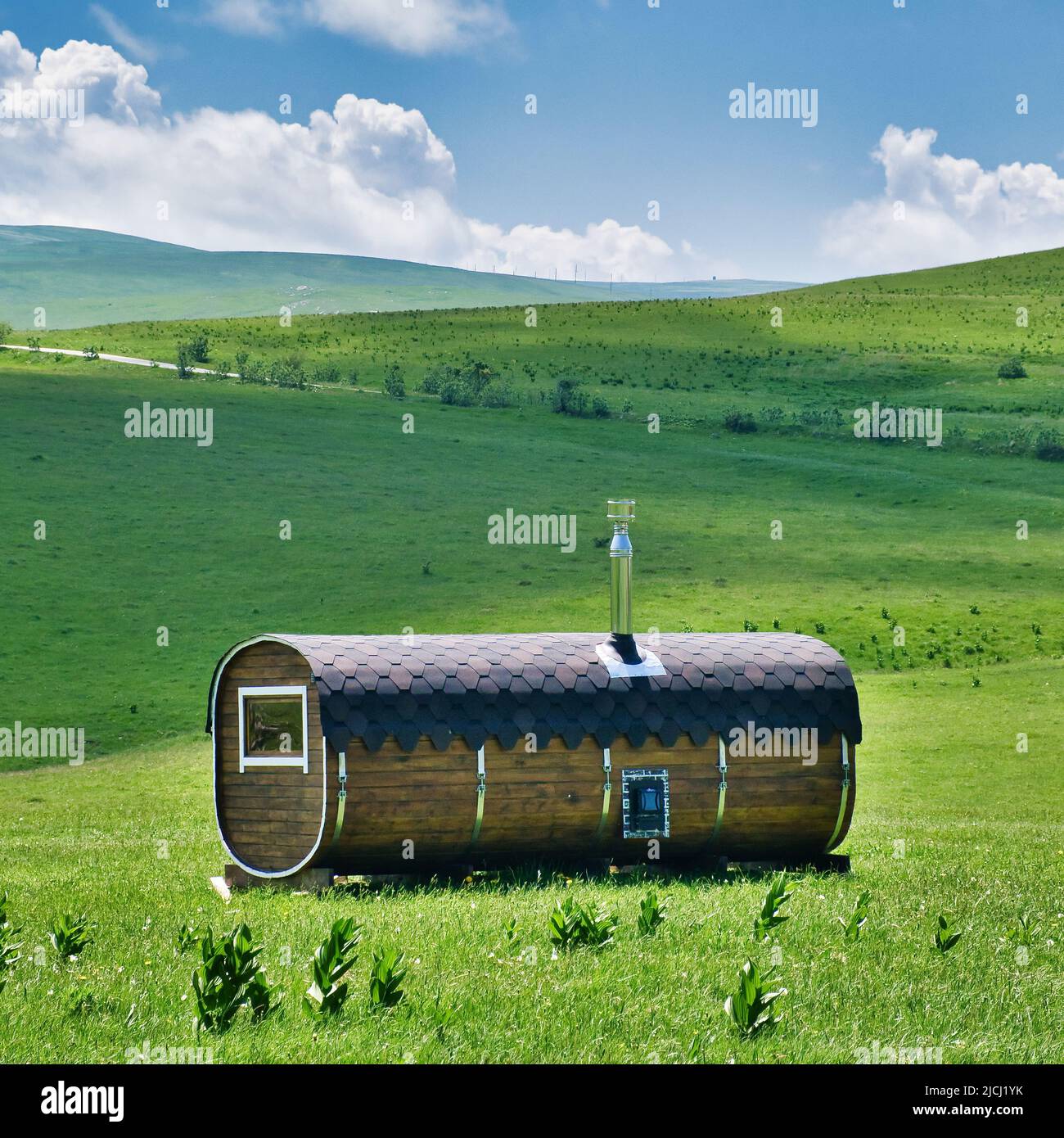 Mobile kompakte Holzsauna oder -Bad. Badehaus in ökologischem Naturplatz im Sommer. Stockfoto