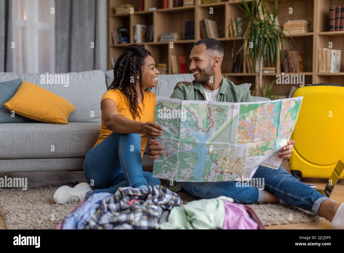 Liebende afroamerikanische Reisende paar Planung Urlaub und mit touristischen Karte, die Wahl Ziel für Sommerurlaub Stockfoto