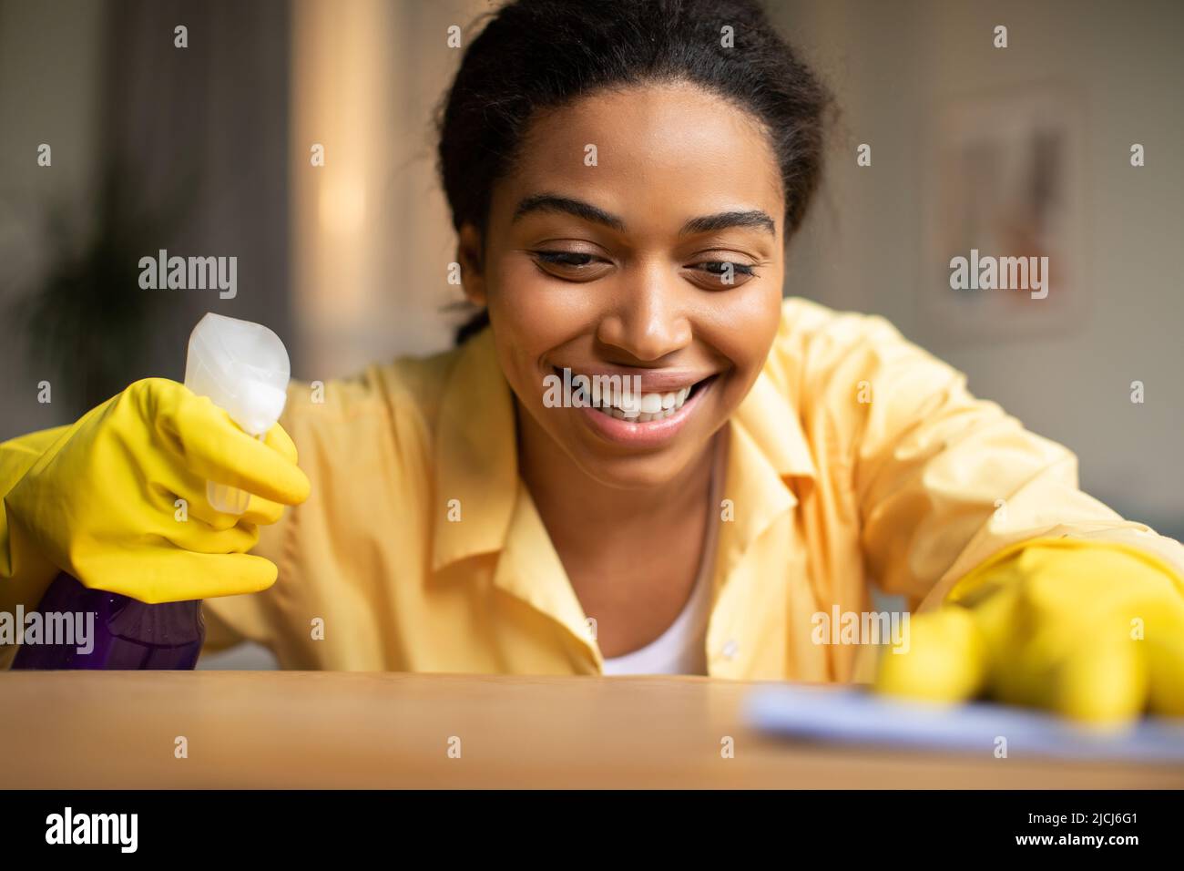 Happy African Woman Staubregal Mit Waschmittel Reinigung Zu Hause Stockfoto