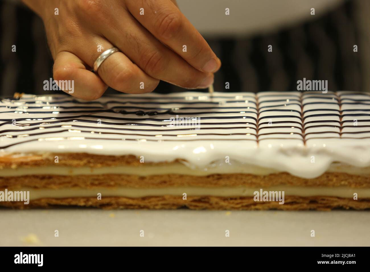 Koch, der „Vanillekuchen“ in der Bäckerfabrik in Istanbul, Türkei, zubereitet. Stockfoto